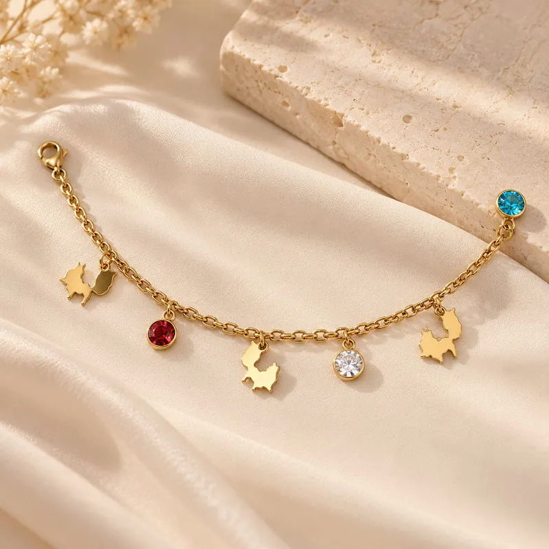 Charmelle bracelet arranged on ivory fabric with its full chain and charms visible